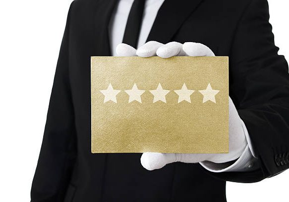 Human hand holding gold card with five stars on it