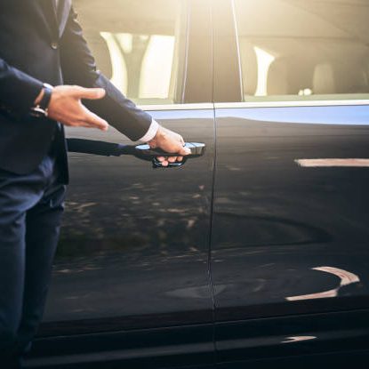 Cropped shot of a well dressed and unrecognizable man opening a car door